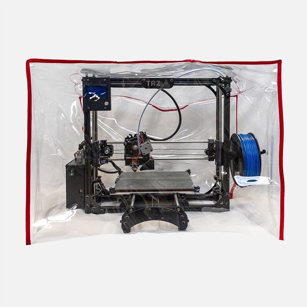 a 3D printer is covered by a clear square shaped custom waterproof cover protective cover with red fabric trim